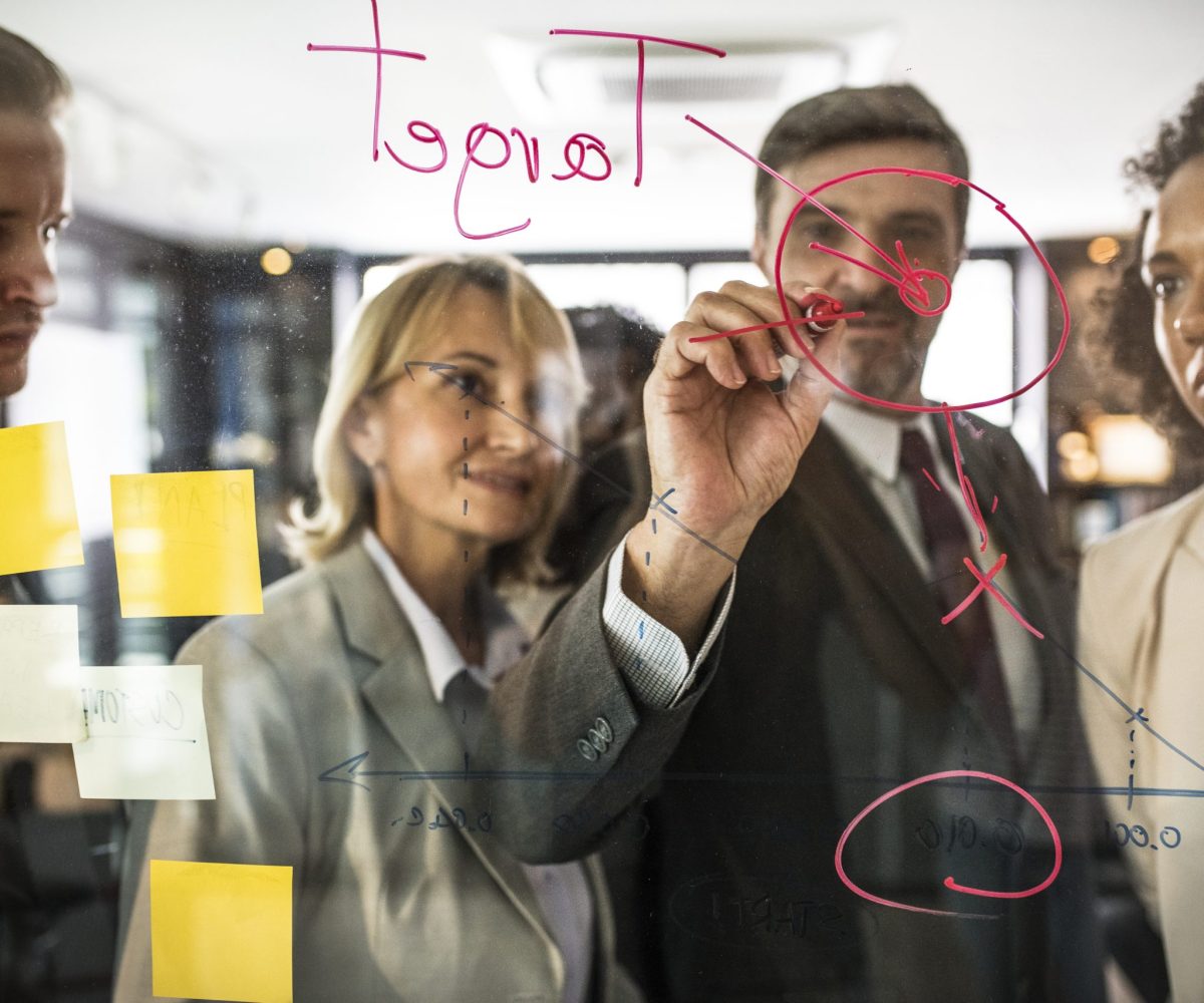 Businesspeople planning on a glass wall